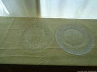 Both clear glass platters shown side by side on a green cloth for scale and condition assessment
