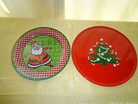 Top view of both Christmas-themed platters side by side on a yellow tablecloth with natural light.