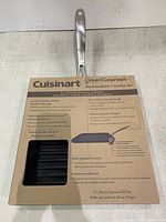 Full view of the Cuisinart GreenGourmet grill pan in its original cardboard packaging with product details visible on the label.