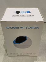 Closed retail box of the HD Smart Wi-Fi Camera labeled Intelligent Camera with features icons and tagline Smart Control from Anywhere.