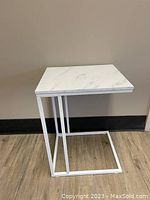 Side/end table shown from side angle, highlighting the C-shaped metal frame and faux marble top.