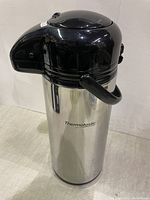 Side view of the Thermotastic vacuum airpot showing stainless steel body, black plastic top with lever and carry handle.