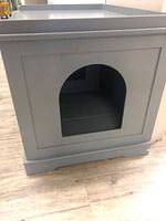 Front view showing arched cat entrance cutout on wooden grey cabinet.