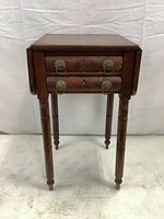 Full front view of the antique drop-leaf side table showing two drawers with brass ring pulls and drop-leaf sides.