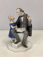 Full front view of the ceramic figurine depicting Hans Christian Andersen with a girl
