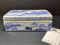 Side view of the rectangular blue and white porcelain box showing detailed landscape painting and a geometric pattern border.