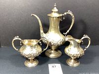 Overall view of three-piece set: coffee pot, sugar bowl and creamer