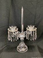 Full front view of entire candelabra showing base, stem, central spike and two arms with prisms