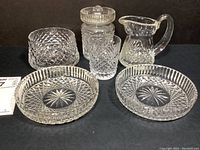 Group photo showing all six Waterford crystal vessels on display against black background.