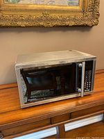 Angled front view of Danby stainless steel microwave showing door and control panel.