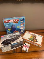 Photo showing three items: Monopoly Junior Finding Dory board game, Tyco Kit model building set, and AMT 280ZX Turbo car model kit all factory sealed.