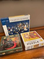 Three puzzles stacked showing box front and side views, all factory sealed in shrink wrap.
