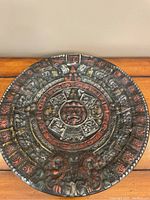 Full view of the circular Aztec wall plaque showing the entire design, colors, and condition.