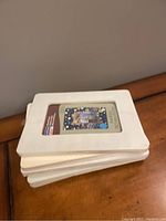 Stacked view of six wooden picture frames sealed in plastic.