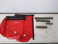 6 MEC Nano Drybags in red and 4 aLOKSAK clear drybags arranged flat on white surface.