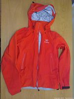 Front view of Arc'teryx jacket laid flat, hood extended