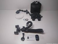 Full lot view showing flexible phone tripod with segmented legs, Bluetooth remote, Aurosports binoculars with soft carrying case, Kingmas pocket loupe behind binoculars.