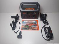 Overview of power station, charging cables, adapters and user manual laid out