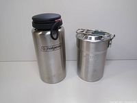 Stanley Adventure Camp Cook Set stainless steel pot with lid next to Nalgene stainless steel flask with black cap