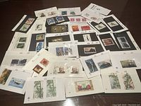 Full view of numerous sheets and cards with mounted vintage Chinese stamps showing diverse themes and colors.