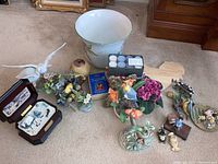 Photo showing spread of ceramic bird figurines, planter bowl, music box, tea light candles, and other small decorative items on carpeted floor.