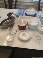 Overview of vintage metal lamb cake mold, Corelle plates, glass bowls, ramekins, Corning dish, Pyrex measuring cups, and the blue glass cake plate with serving set.