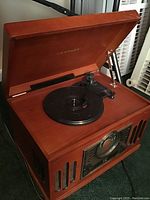 Top open view of Crosley wooden radio unit showing the turntable and tonearm with Crosley logo inside the lid.