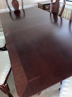 Top view showing the overall rectangular tabletop with two leaves in place and the dark polished wood surface. Some reflections and minor wear visible.