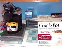 Keurig single cup coffee maker, pod storage drawer, My K-Cup filters, Cuisinart food chopper, Rival Crock-Pot slow cooker boxed, and Hamilton Beach toaster oven on a table