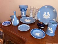Overview of Wedgwood Jasperware items, Limoges trinket box, and glass angels on wooden surface.
