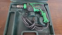 Hitachi FDV 16VB2 hammer drill in green and black in molded plastic carrying case, power cord attached.