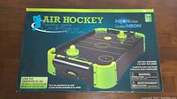 Box of Neon Color Tabletop Air Hockey Game showing front and side views with game size and battery requirements