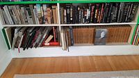 Bookshelves filled with assorted books including fiction and non-fiction, showing variety in book size and color.