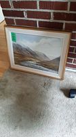 Framed print leaning against brick fireplace and wood floor