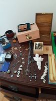 Overall view of dresser top showing jewelry boxes, assorted jewelry, figurines