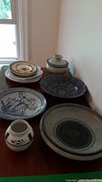 Full view of eight assorted pottery pieces on wooden surface
