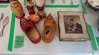Photo showing two wooden eggs, three painted stacking dolls, two wooden shoes, and the vanity box arranged on a table.