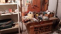 Workbench with assorted tools and small hardware items, work surface cluttered with various tools and cords
