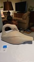 Full side profile of the wooden swan sitting on a surface in a living room environment.