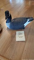 Photo of the Canada Goose decoy showing detailed hand-painted feathers and overall shape on a wooden floor.