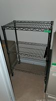 Three-tier stainless steel wire cart with open wire shelving and cylindrical legs, seen from two angles