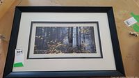Framed and matted photo 'Algonquin Morning' showing full framed piece on table with auction tag.