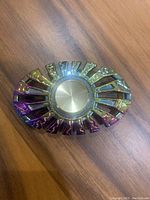 Close-up photo of the chrome rainbow color fidget spinner, showing detailed gradient finish and circular center bearing.