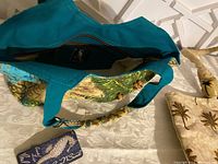 Top view of the interior of the Paul Brent Coastal Life blue and beige beach bag showing turquoise handles and inner lining, with visible Paul Brent tag attached.