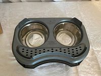 Top view of new double cat/dog bowl with stainless steel inserts and black plastic holder with non-slip base.