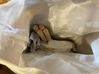 Wooden poles and folded fabric of teepee inside a fabric bag, showing component parts.