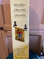 Photo of the boxed Estate Collection Mantel Flag Holder with dimensional and assembly information on packaging.