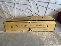 Box packaging labeled 'Pet Steps / Pet Stairs' indicating wooden pet stairs for pets to climb onto beds or sofas.