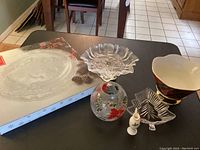 Overview of Mikasa Christmas serving platter, two candy dishes, candle holder, tiny Christmas vase, and Christmas plaid fruit holder bowl on table