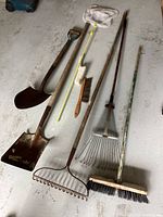 Wide view of all garden tools and butterfly net displayed on floor.